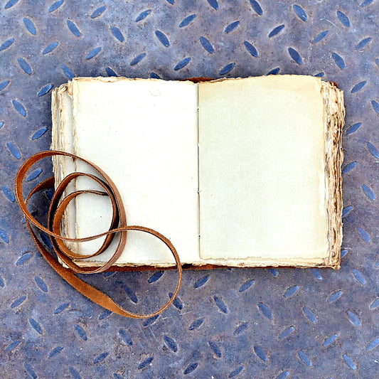 Tan leather journal open showing deckle edge pages
