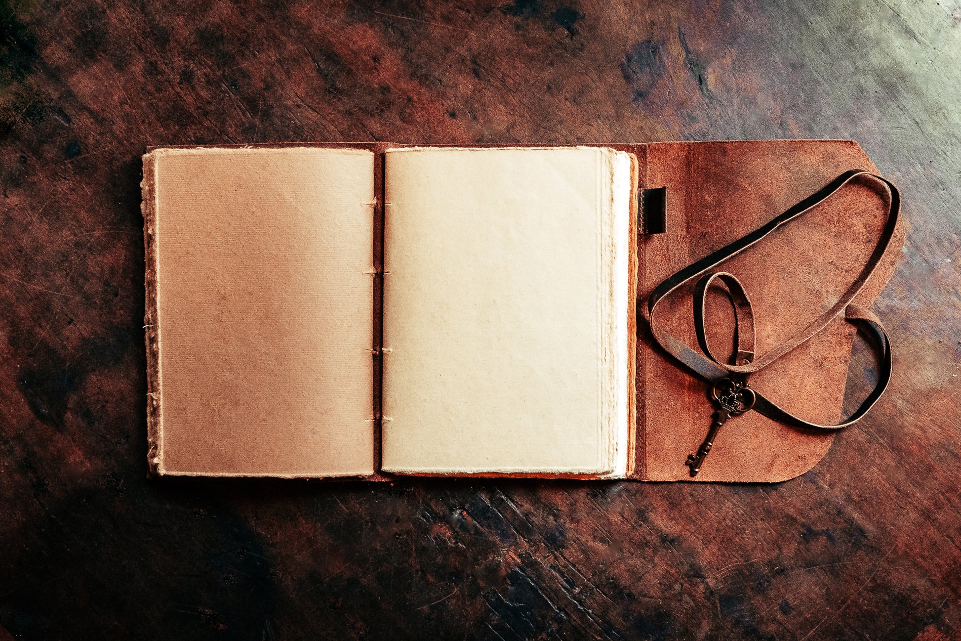 Brown leather journal with key being held