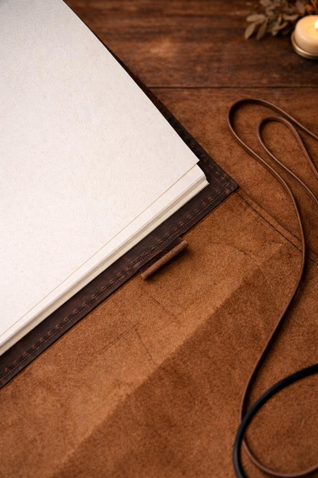 Leather journal with blank white pages and leather strap closure