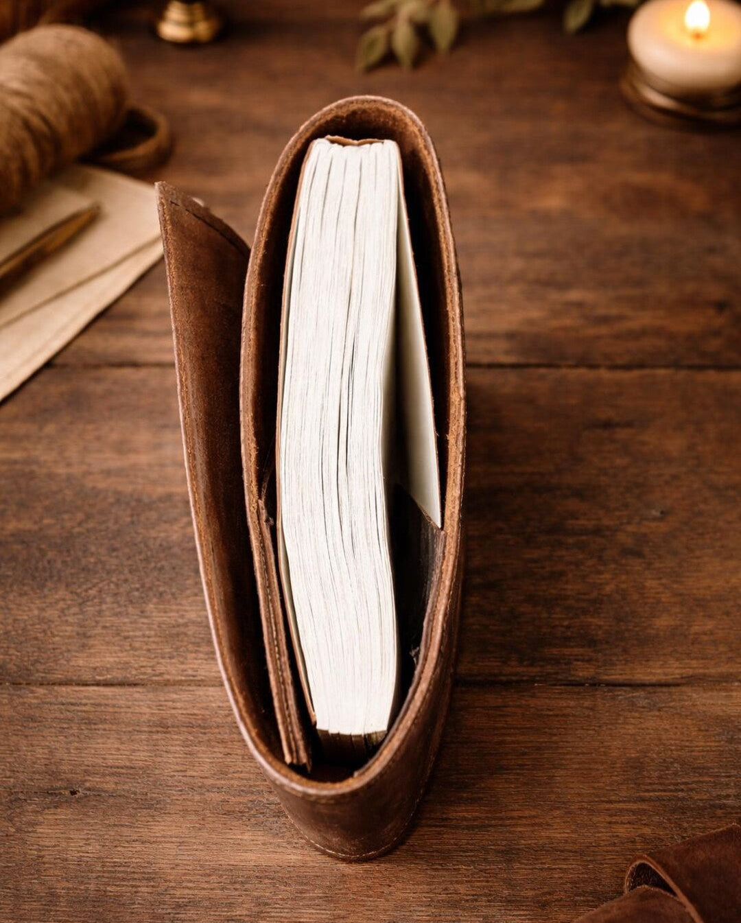 Leather journal open on wooden surface showing thick paper