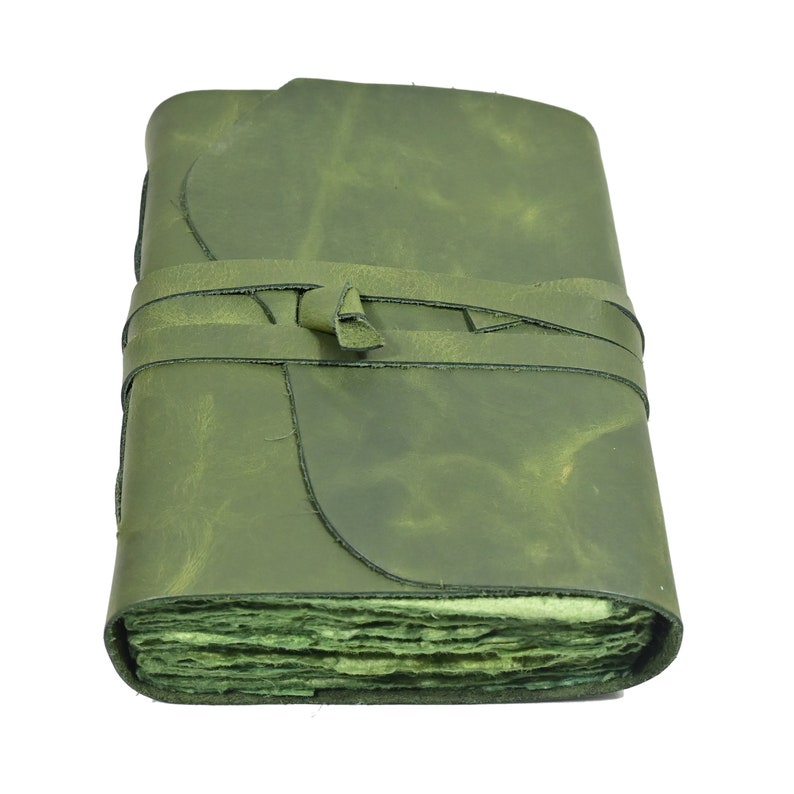 Green leather journal open showing unlined pages