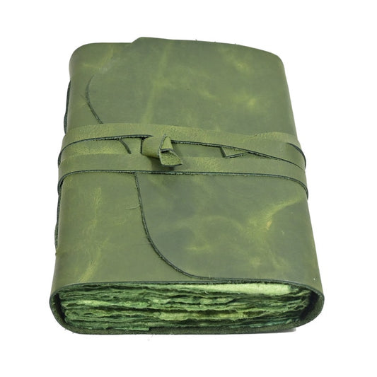 Green leather journal open showing unlined pages