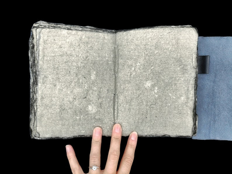 Black leather journal open showing antique gray pages