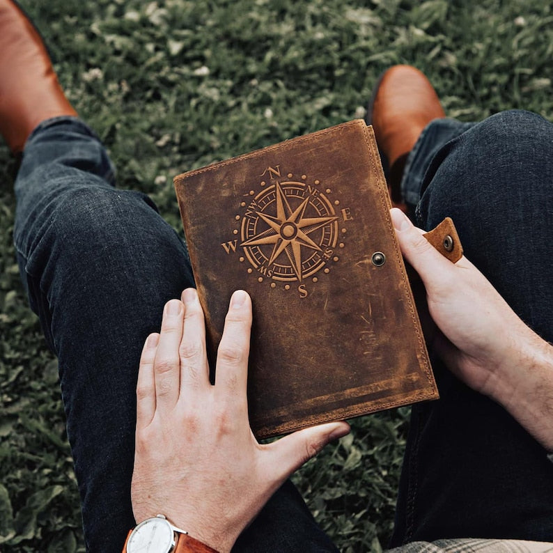 Compass travel journal open with lined pages