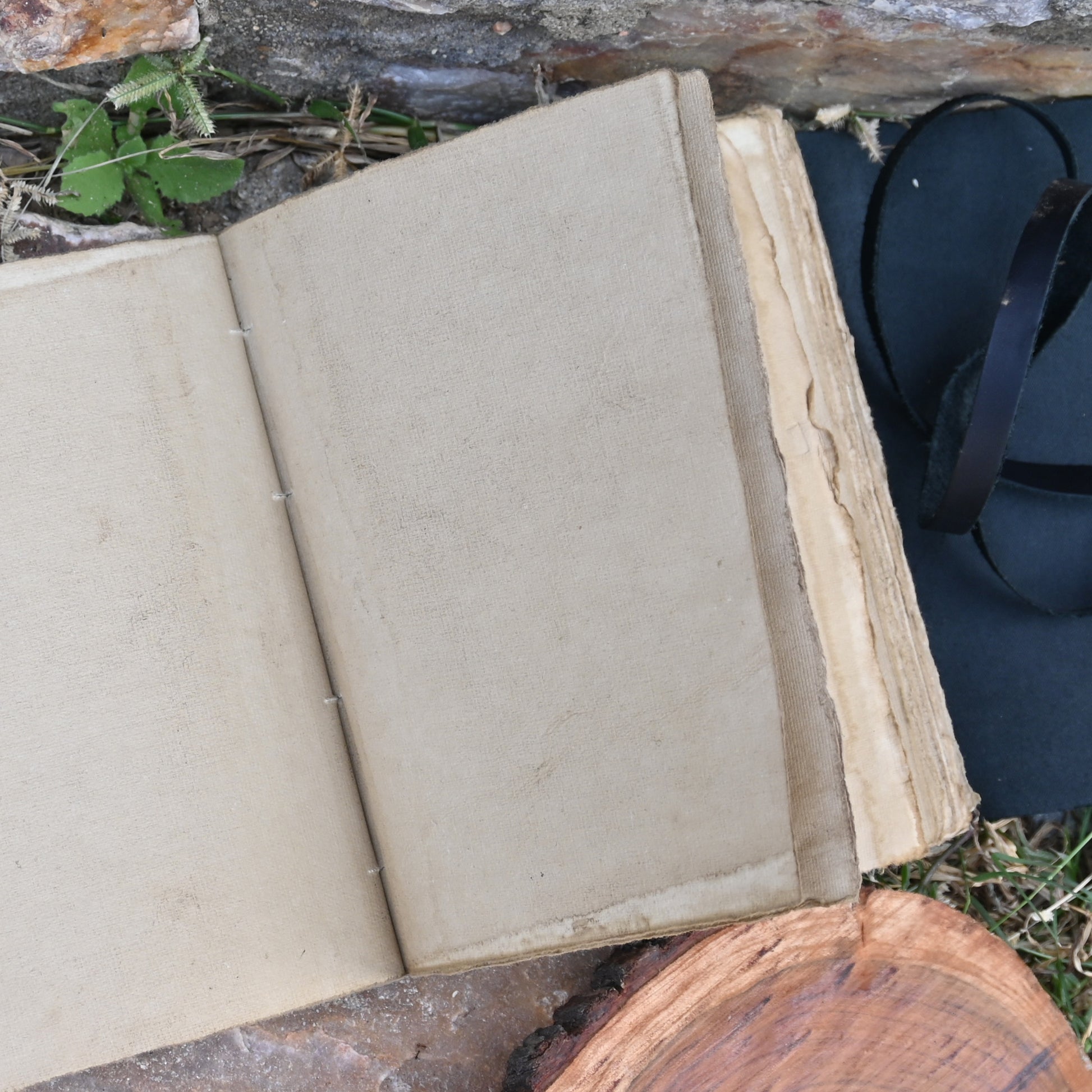 Black leather journal open showing deckle edge pages