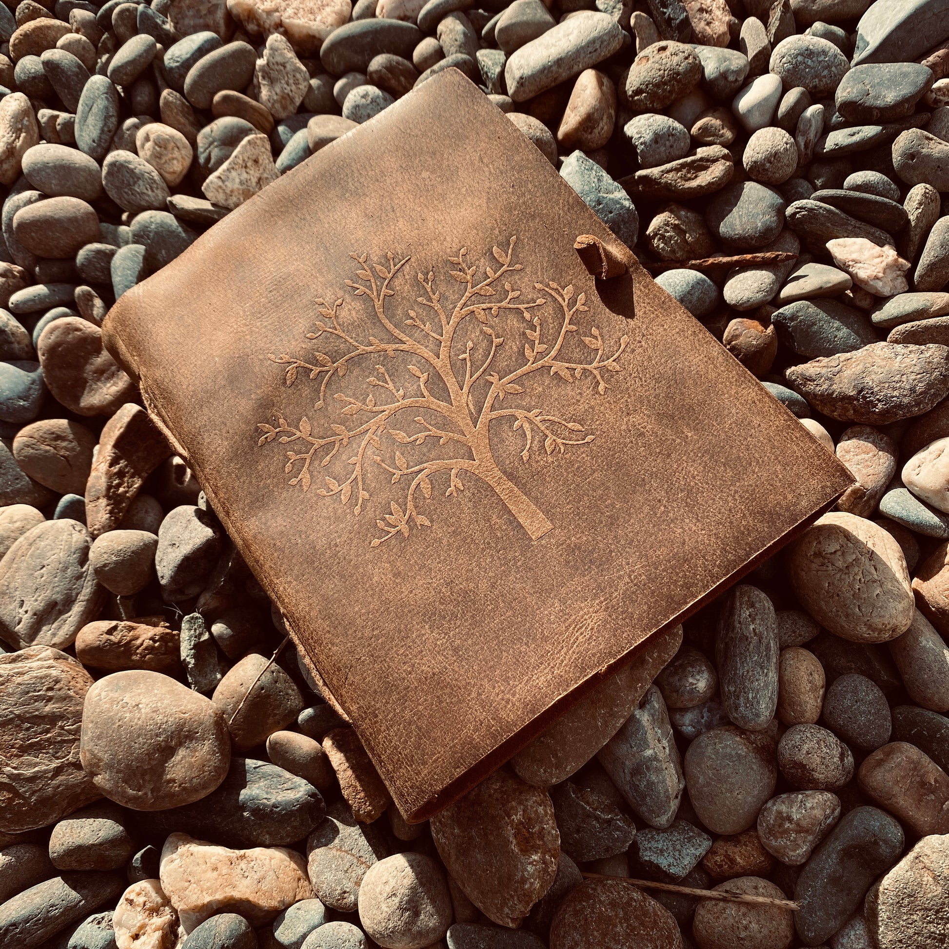 Tree of Life leather journal open showing unlined pages