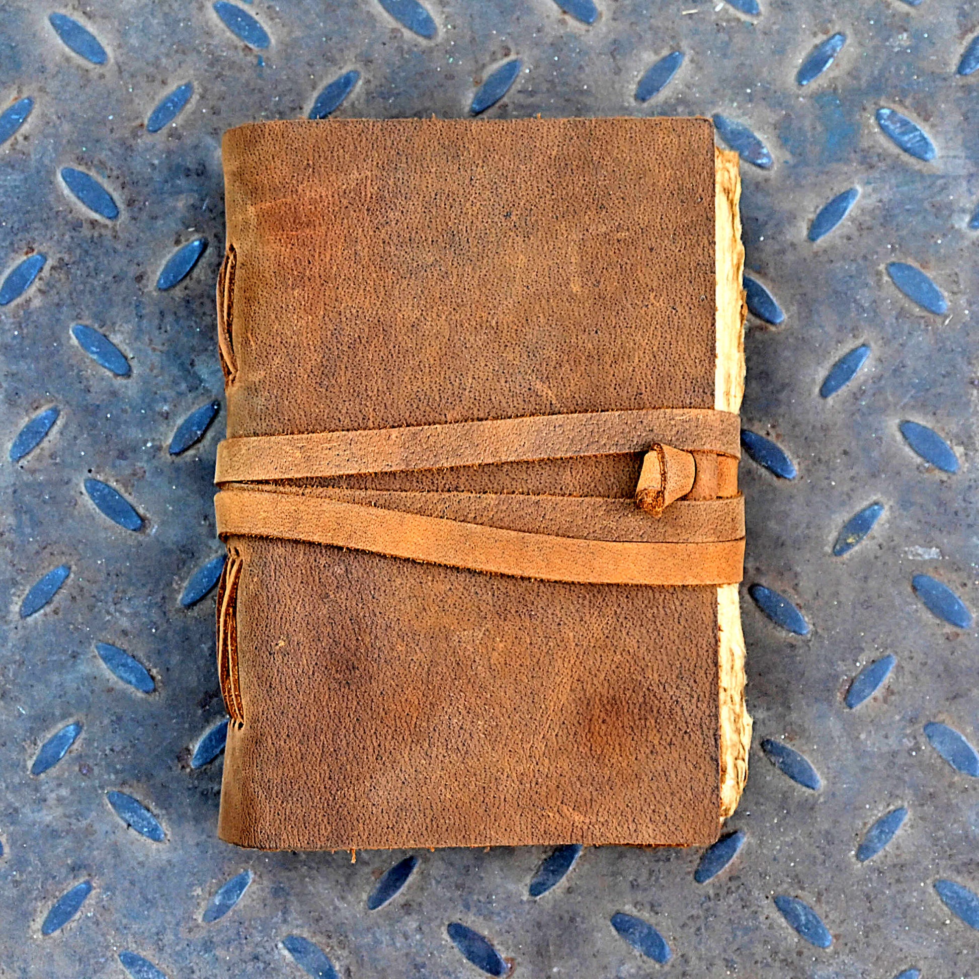 Tan vintage leather journal being written in